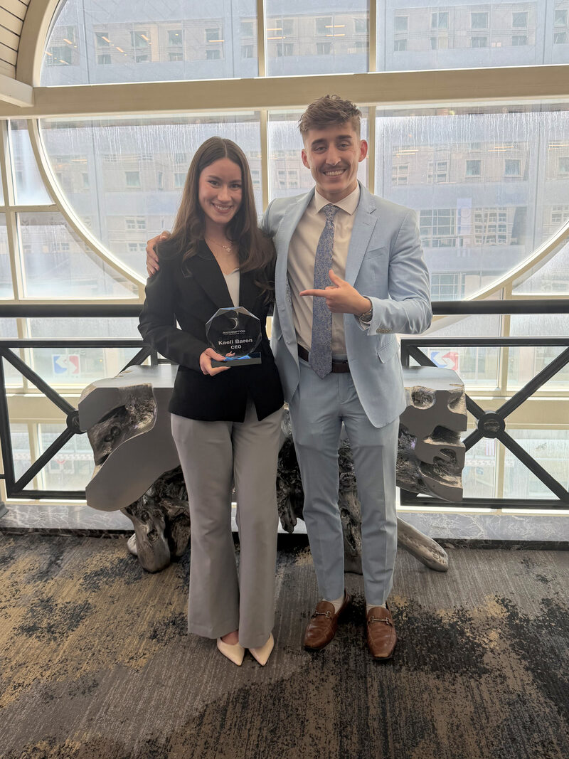 Two Raedemption Marketing team members holding a company award